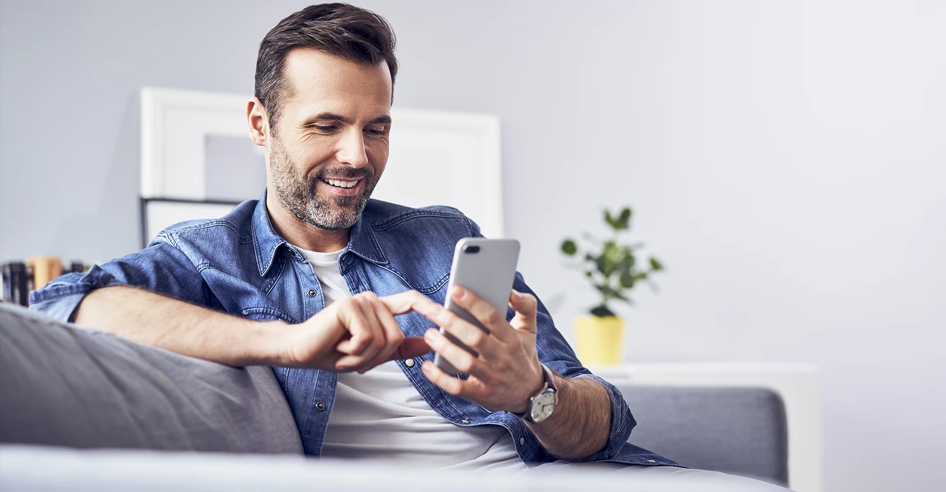 Contact Center Solutions Man with Cell phone working from home on Cloud Contact Center Solution